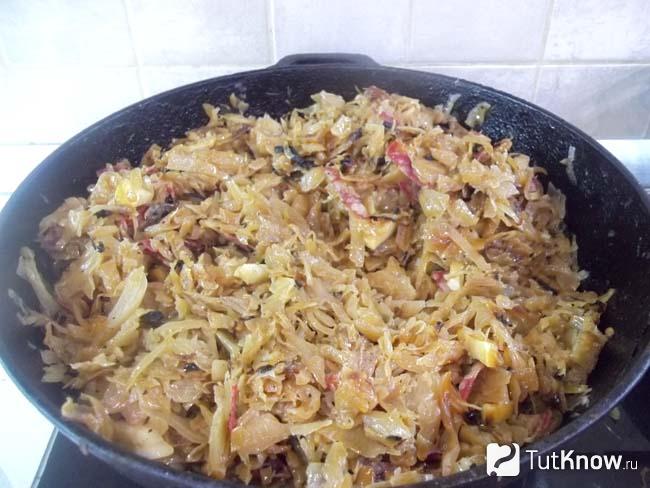 Готовая тушеная капуста с копченой колбасой и яблоками