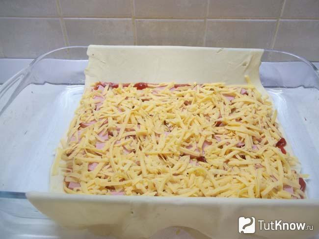 На тесто выложен натертый сыр