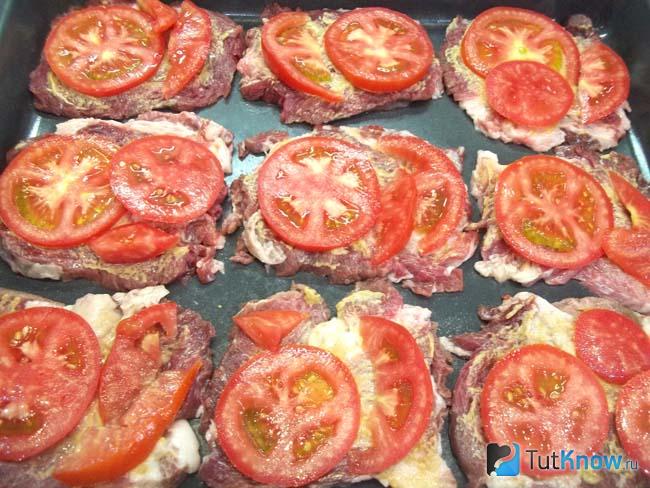 На мясо выложены помидоры