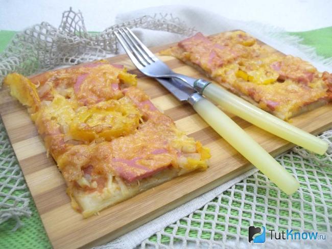 Готовая пицца маринара с колбасой, сыром и помидорами нарезана кусочками