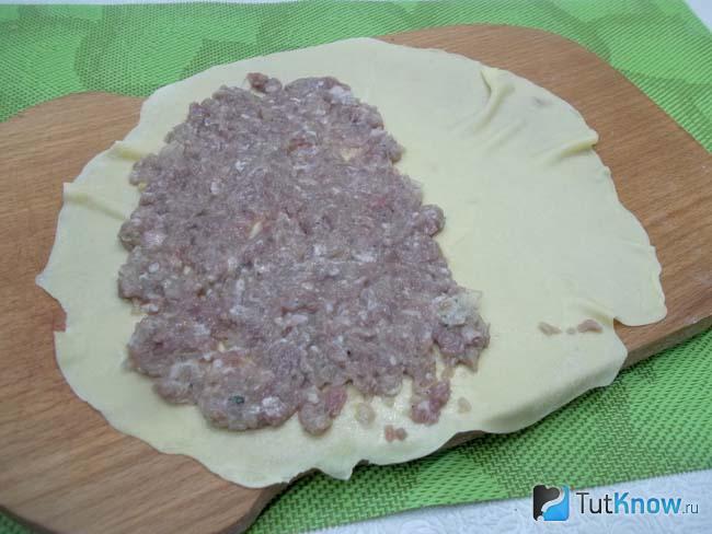 На половину теста выложена мясная начинка