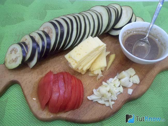 Баклажаны, помидоры, сыр и чеснок нарезаны тонкими дольками