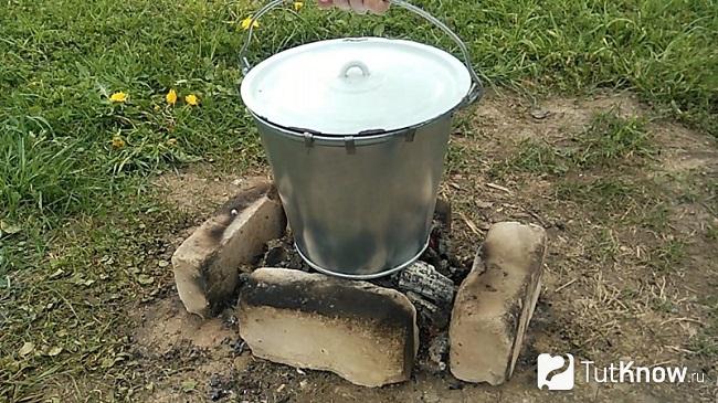 Металлическое ведро на огне