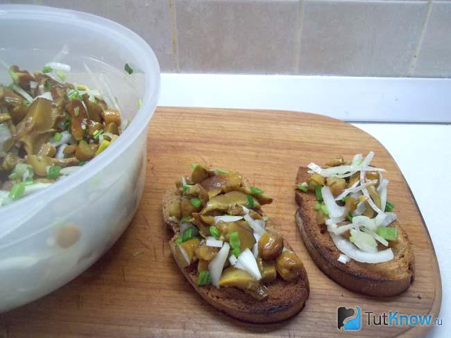 Готовые гренки с маринованными грибами и луком