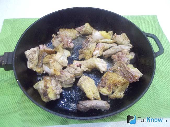Курица нарезана и жарится в сковороде