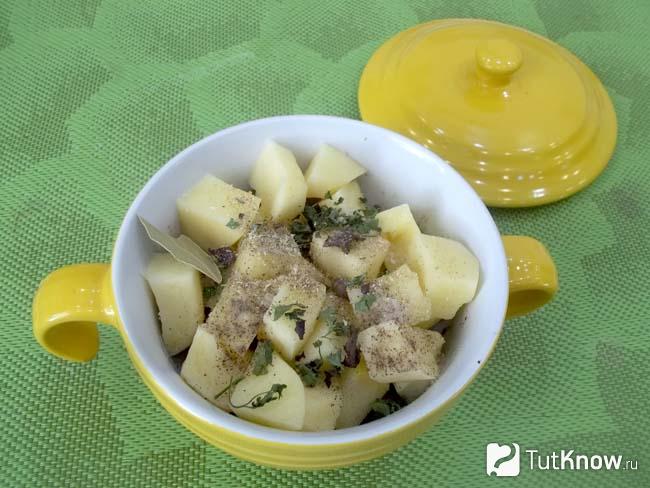 Продукты приправлены пряностями и картофельные горшочки с печенью и кабачками отправлены в духовку