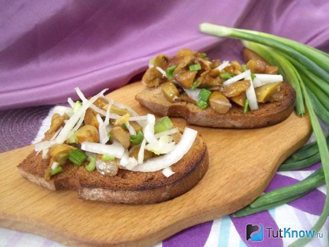Готовые гренки с маринованными грибами и луком