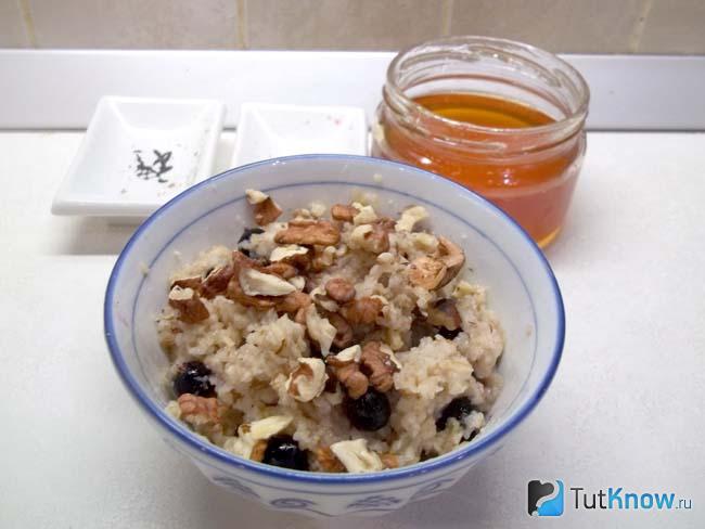 Готовая овсяная каша с черной смородиной, грецкими орехами и медом