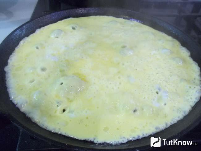 Яйца с молоком и сыром жарятся на сковороде
