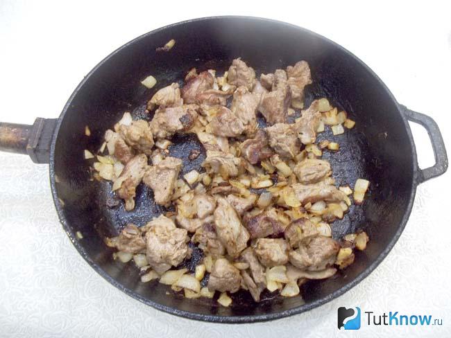 Готовая жареная баранина с луком на сковороде