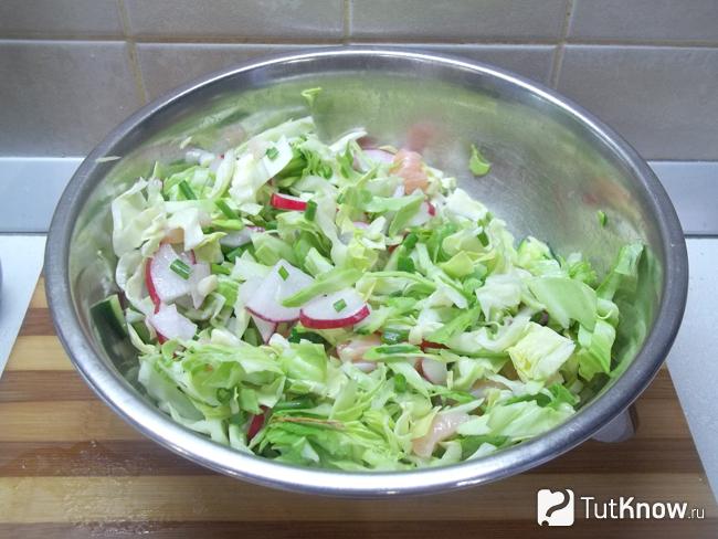 Готовый салат с красной рыбой, огурцом и молодой капустой