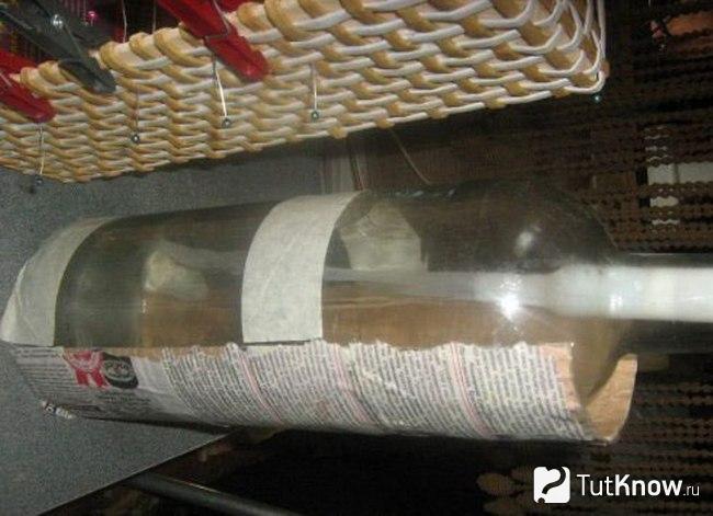 Смоченный картон прикреплен к бутылке