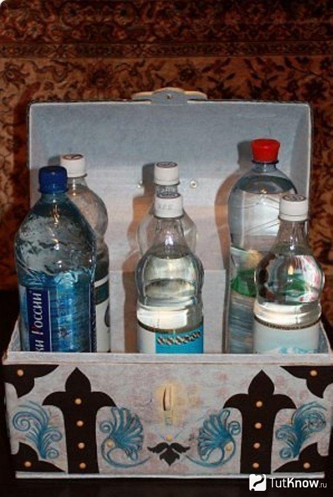Бутылки стоят в сундуке из коробки