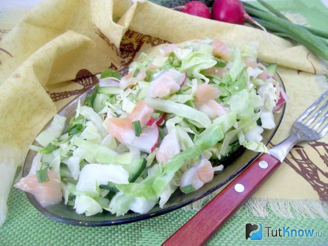 Готовый салат с красной рыбой, огурцом и молодой капустой