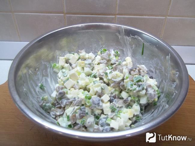 Готовый салат с маринованными грибами, плавленым сыром, яйцами, зеленым луком и майонезом