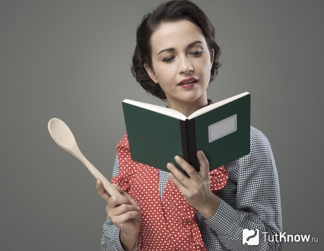 Женщина читает кулинарную книгу
