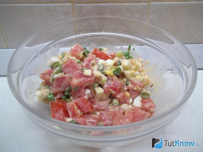 Готовый салат с помидорами, яйцами и зеленым луком