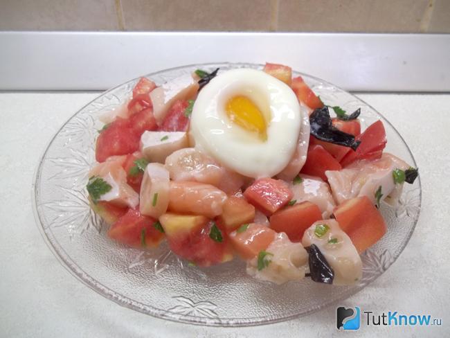 Готовый салат с красной рыбой, помидорами и яйцом-пашот
