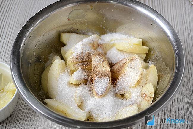 Нарезанные яблоки, посыпанные сахаром и корицей