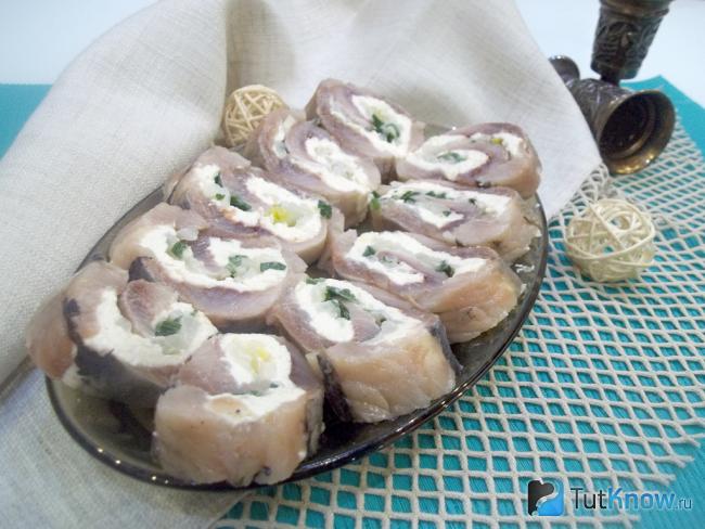 Готовый рулет из сельди с луком и плавленым сыром