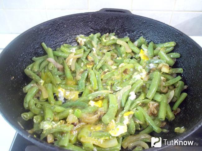 Готовая жареная спаржевая фасоль с луком в яйце