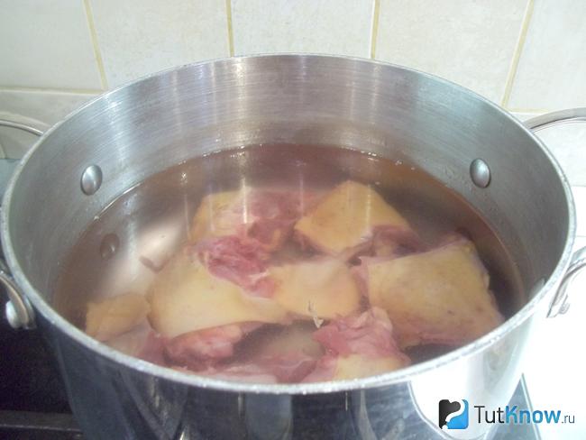 Курица сложена в кастрюлю и залита водой