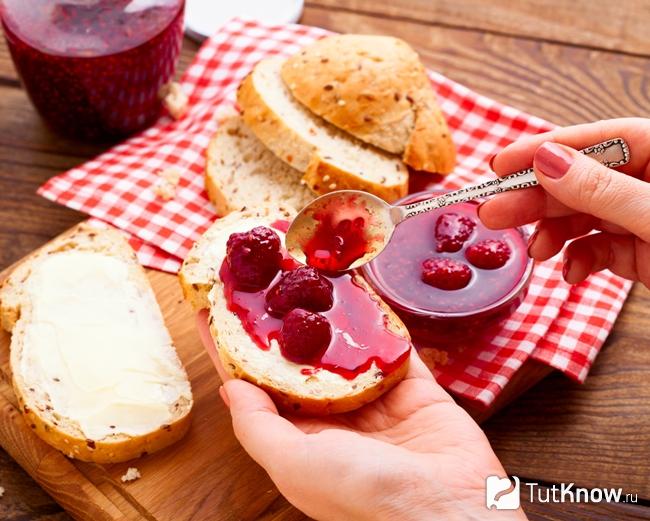 Девушка кушает малиновое варенье