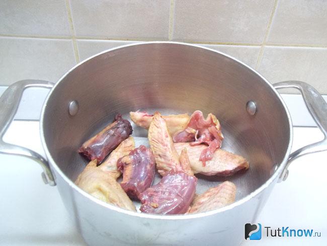 В кастрюлю сложена курица
