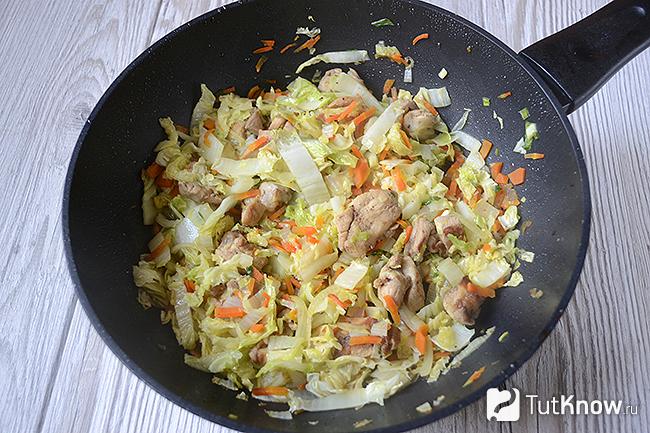 Пекинская капуста с курицей тушится на сковороде