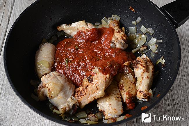 Куриные крылышки с луком и томатным соусом на сковороде