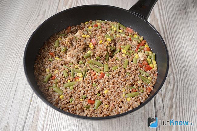 Готовая гречка с курицей и овощами на сковороде