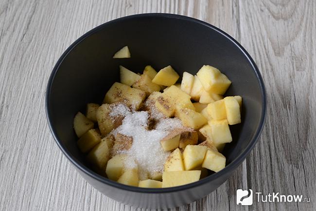 Нарезанные яблоки, посыпанные сахаром и корицей