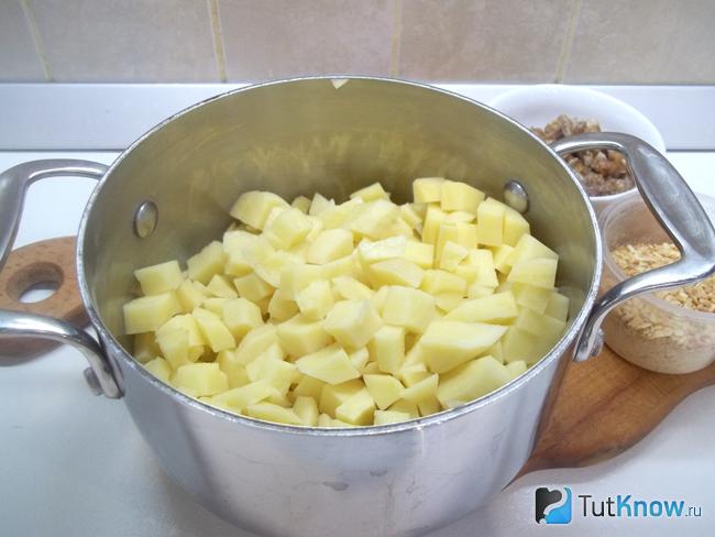 Картофель очищен, нарезан кубиками и сложен в кастрюлю