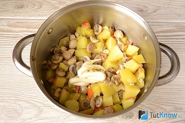 Добавление майонеза и специй в картофель с грибами