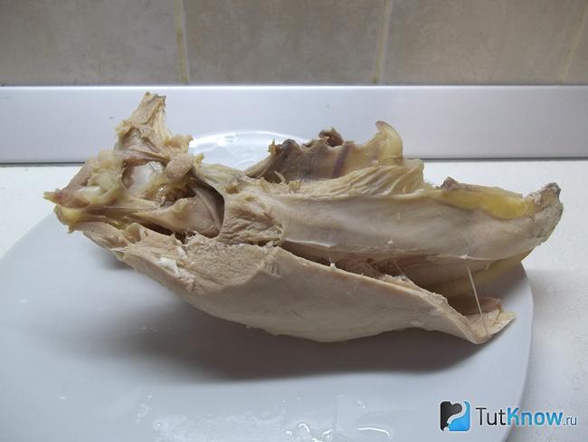 Курица извлечена из кастрюли, мясо снято с кости