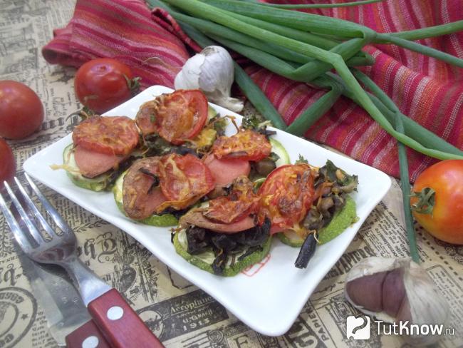 Готовые кабачки запеченные с колбасой, грибами и сыром