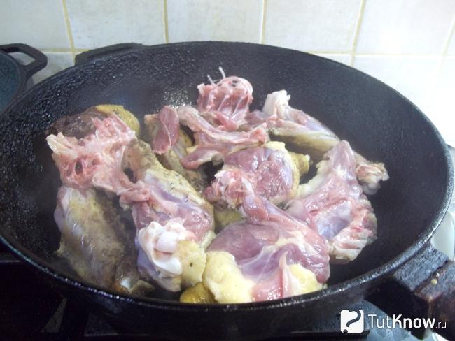 Утка нарезана кусочками и жарится в сковороде