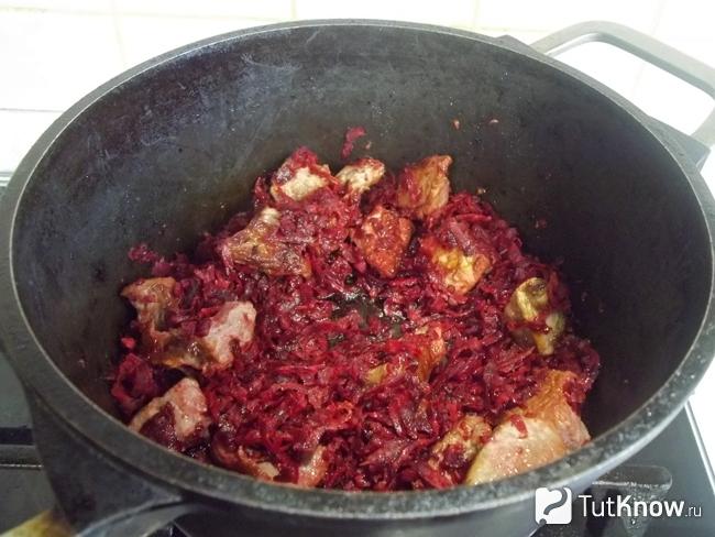В кастрюлю жарится мясо со свеклой