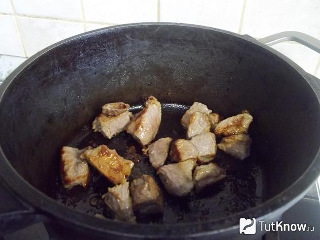 В кастрюле жарится мясо до золотистости