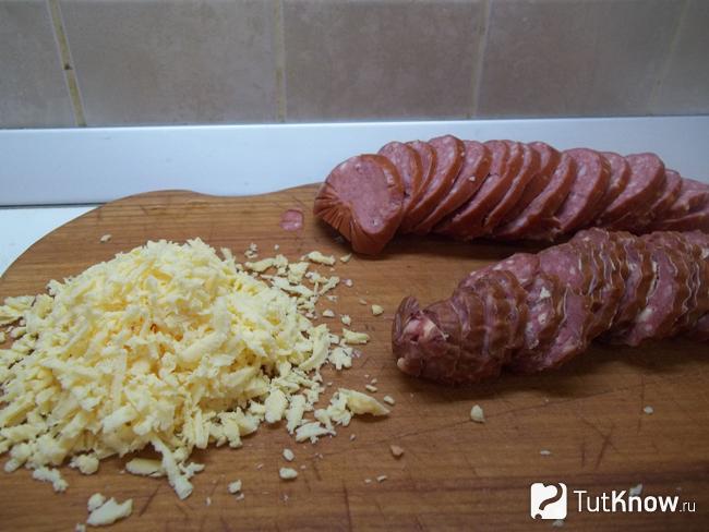 Колбаса нарезана кольцами, сыр натерт на терке