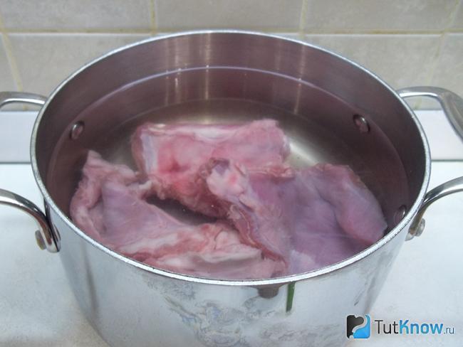 Кроль нарезан кусочками, выложен в кастрюлю и залит водой