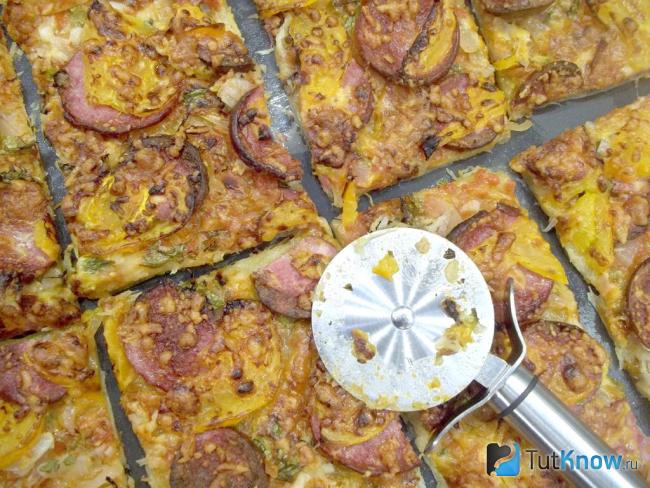 Готовый открытый пирог из слоеного теста с колбасой и сыром
