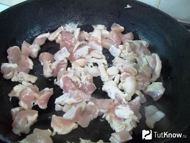 В сковороде жарится нарезанная курица