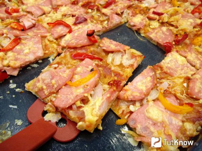 Готовый открытый пирог из слоеного теста с колбасой и сыром
