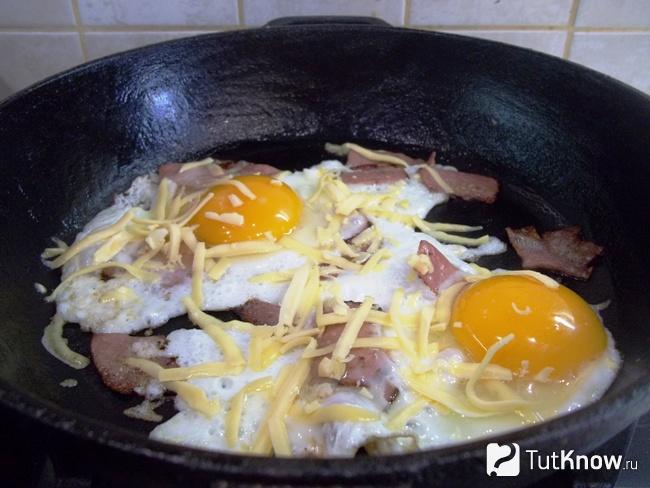 Яйца присыпаны сырной стружкой