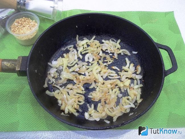 Лук с перцами жарятся в сковороде