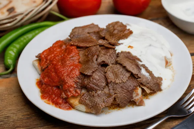 Искендер-кебаб: слои мяса, йогурта, томатного соуса