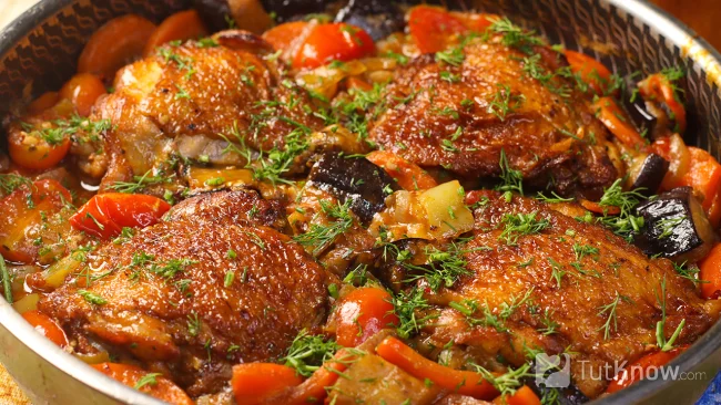 Готовая курица с баклажанами и овощами в сковороде